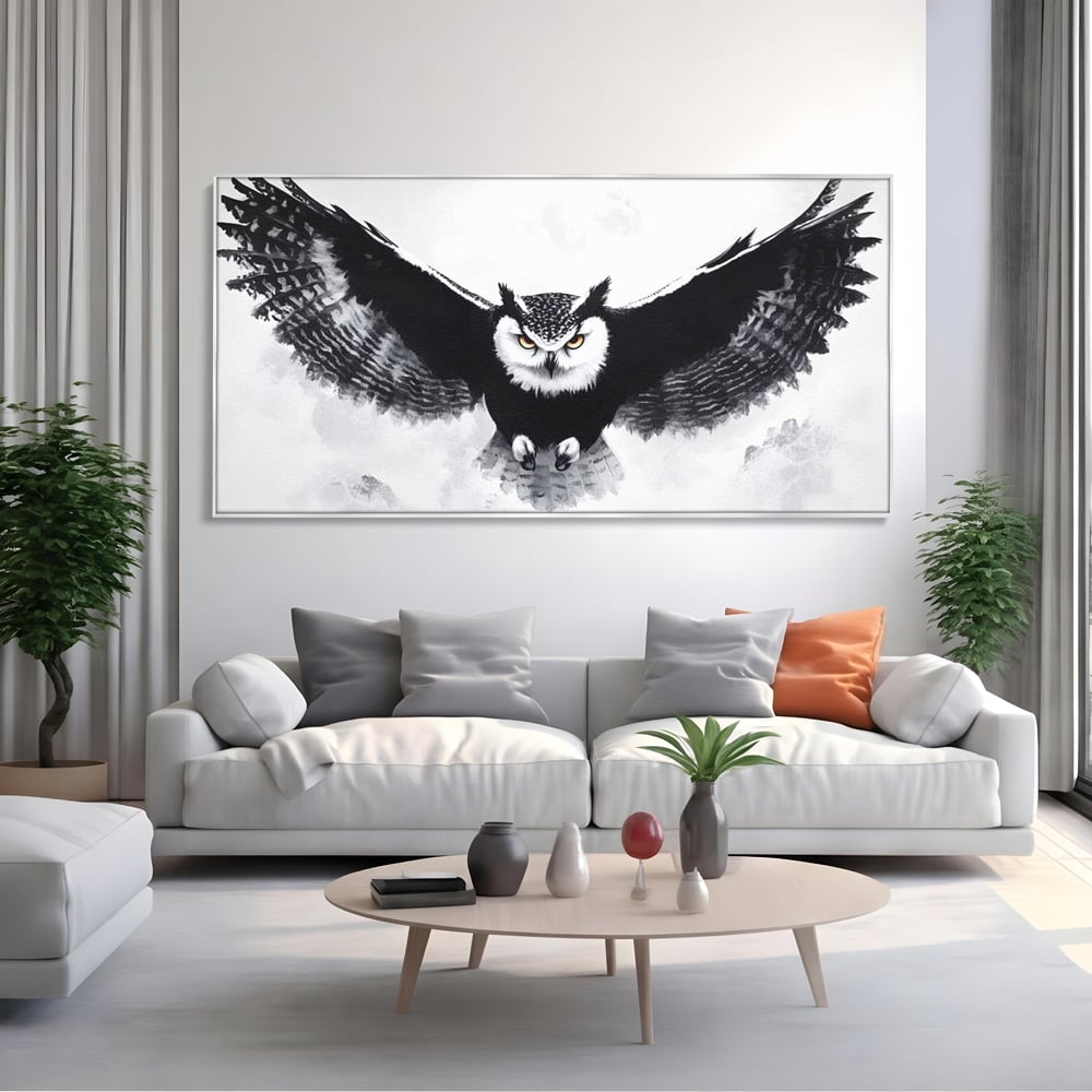 Tablou canvas cu tablou canvas cu bufnita in zbor, in rama de aluminiu argintiu, pe perete intr-un living